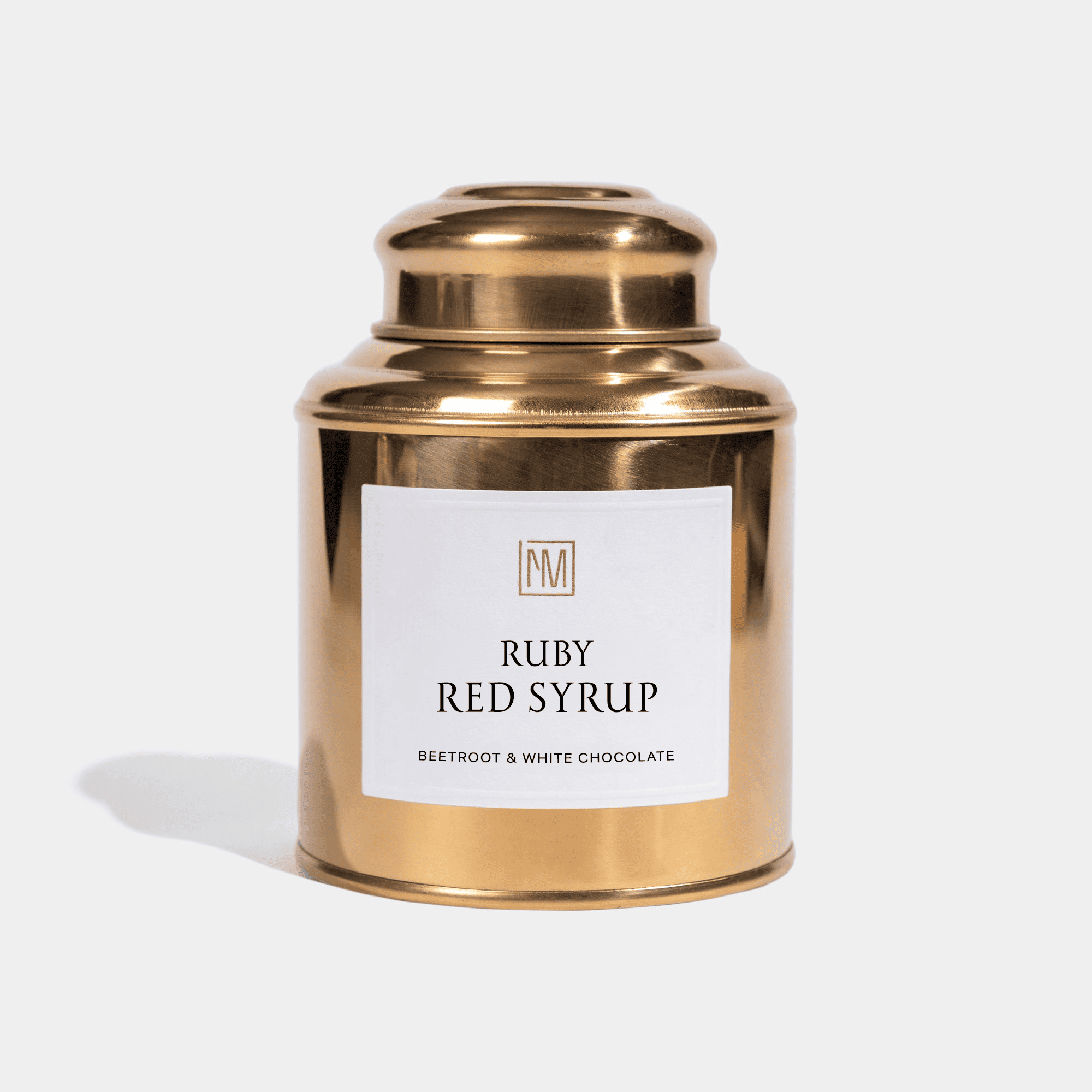 lata de chá dourada com xarope vermelho rubi